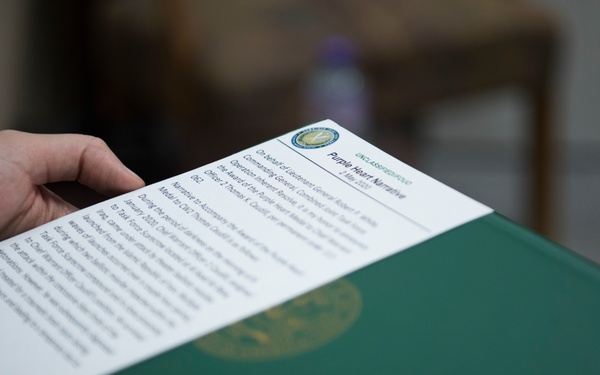 Brig. Gen. Stephen Jost presents Purple Heart Medal to Chief Warrant Officer 2 Thomas Caudill