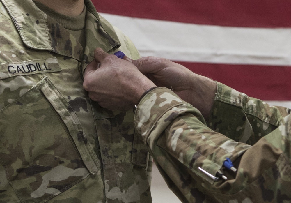 Brig. Gen. Stephen Jost presents the Purple Heart Medal to Chief Warrant Officer 2 Thomas Caudill