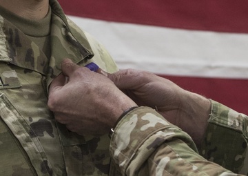 Brig. Gen. Stephen Jost presents the Purple Heart Medal to Chief Warrant Officer 2 Thomas Caudill