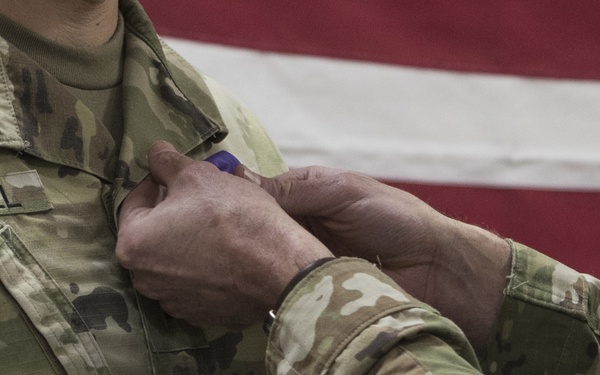 Brig. Gen. Stephen Jost presents the Purple Heart Medal to Chief Warrant Officer 2 Thomas Caudill