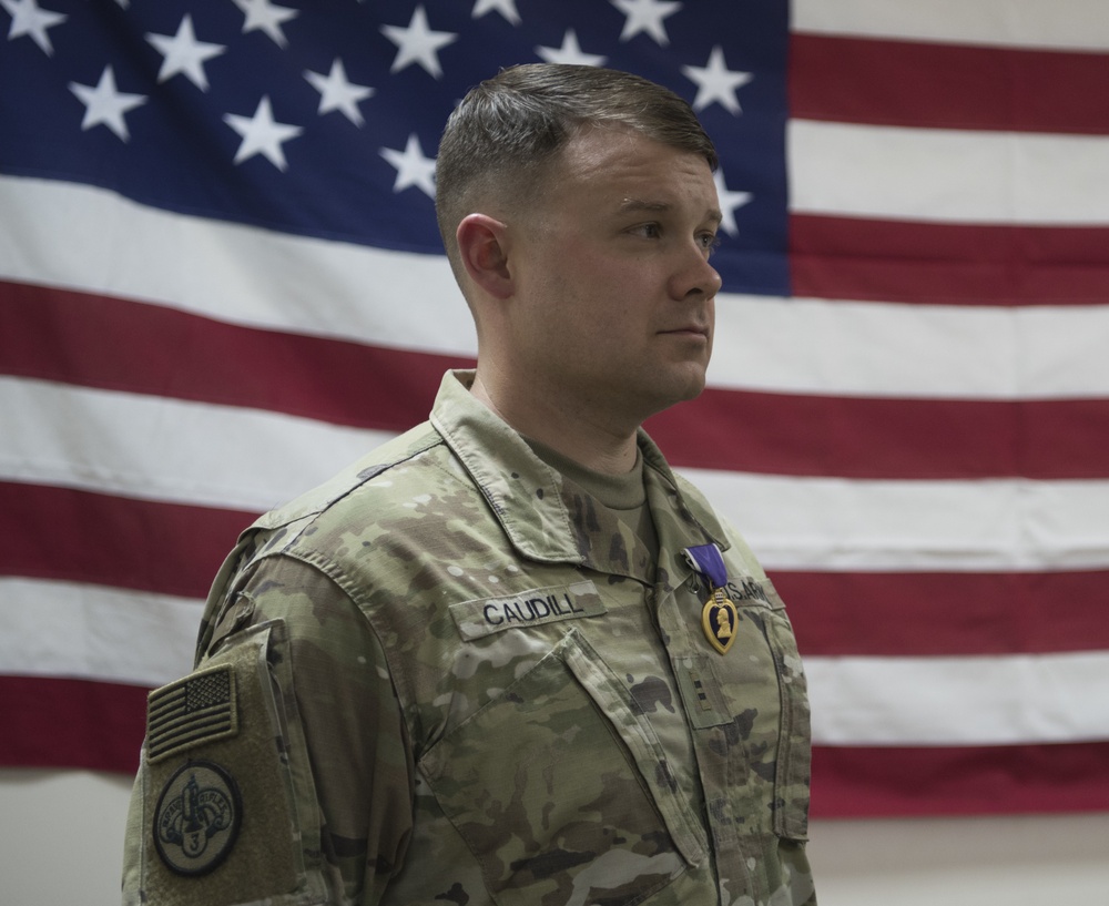 Brig. Gen. Stephen Jost presents the Purple Heart Medal to Chief Warrant Officer 2 Thomas Caudill
