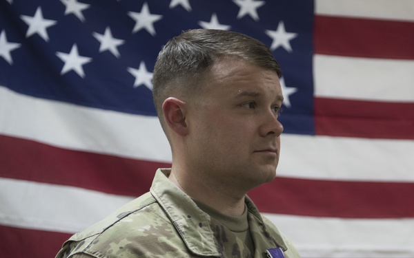 Brig. Gen. Stephen Jost presents the Purple Heart Medal to Chief Warrant Officer 2 Thomas Caudill