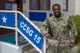 IS2 Joshua James stands in front of the entrance of Commander, Carrier Strike Group (CCSG) 15