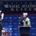 Two military personnel in olive green flight suits and khaki covers are conducting what appears to be a formal oath or swearing-in ceremony at the National Naval Aviation Museum. One individual stands at a podium while both have their right hands raised. A medical walker is visible near the left individual, suggesting a recent injury or mobility assistance need.