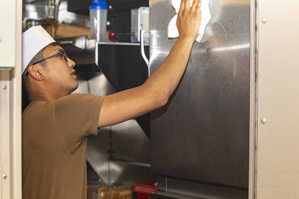 Sailors clean the galley