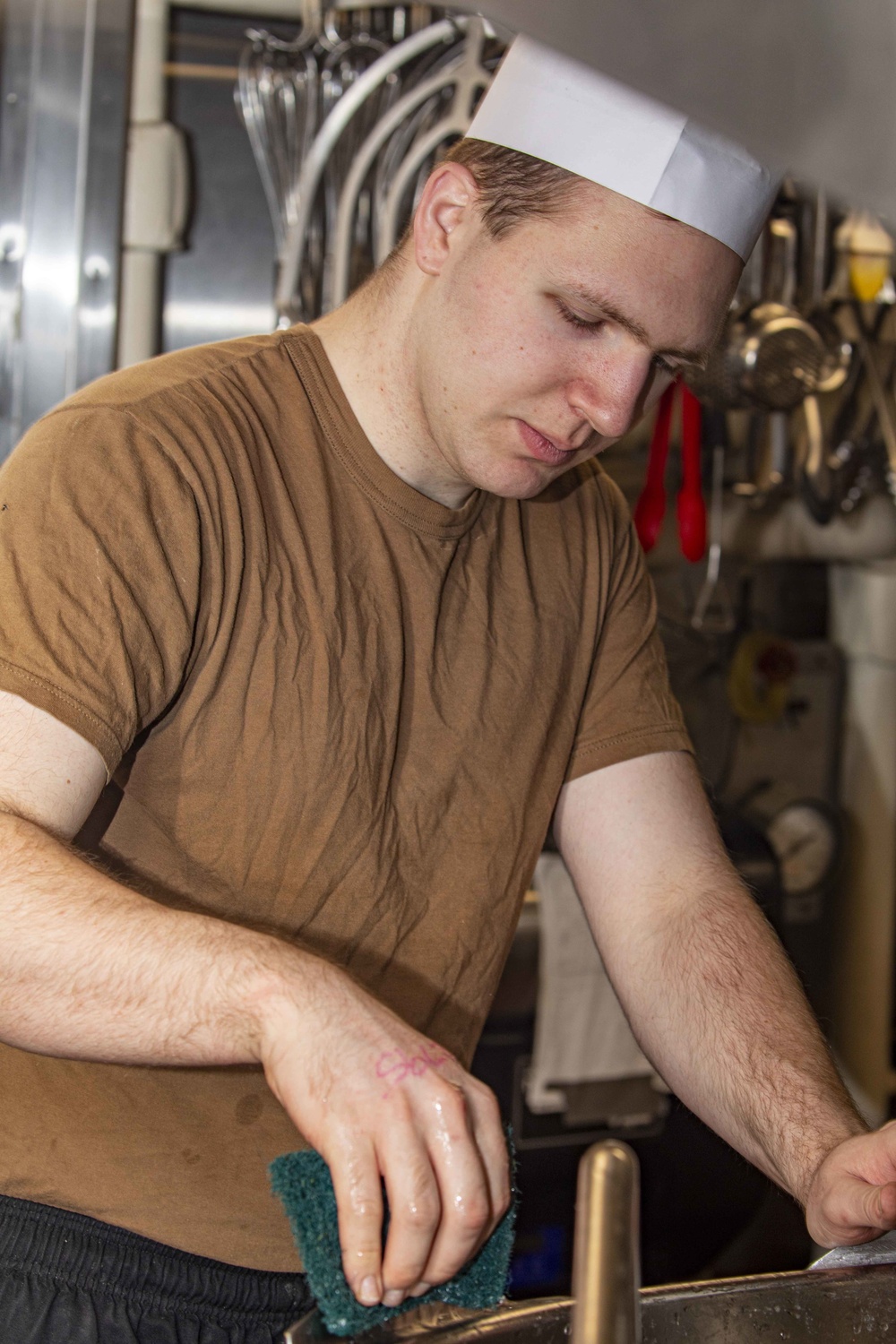 Sailors clean the galley