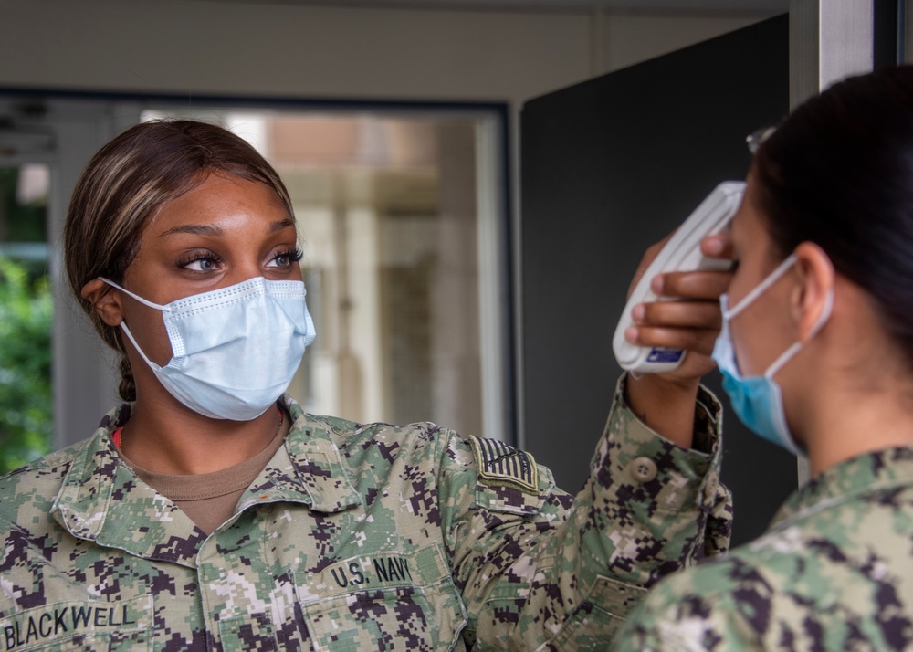 Hospitalman checks Sailor's tempterature