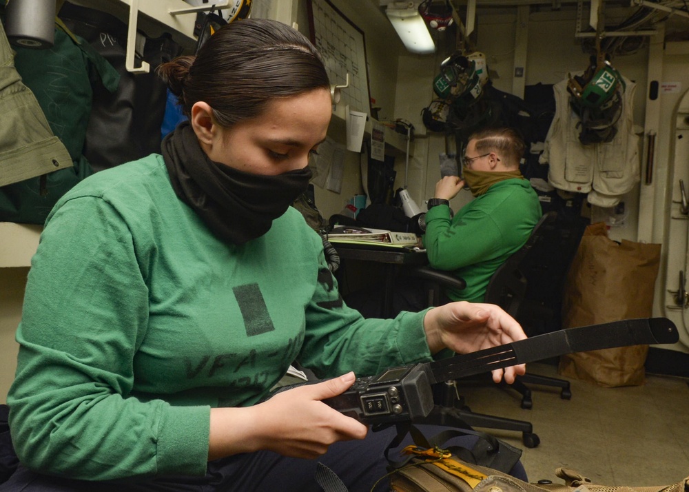 U.S. Navy Sailors Inspect Fighter Pilot Equipment