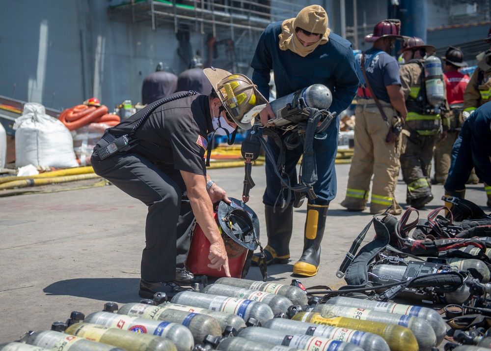 Sailors and Federal San Diego Firefighters fight fire aboard USS Bonhomme Richard