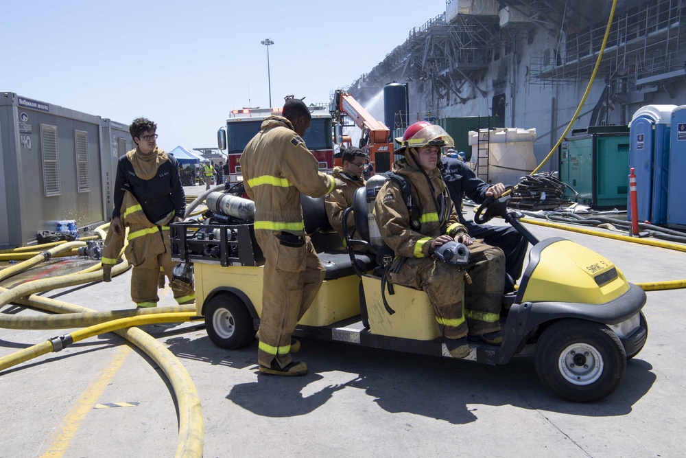 Sailors and Federal San Diego Firefighters fight fire aboard USS Bonhomme Richard