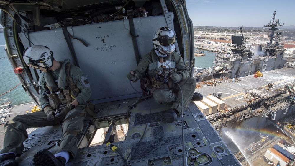 Sailors and federal San Diego firefighters fight fire aboard USS Bonhomme Richard