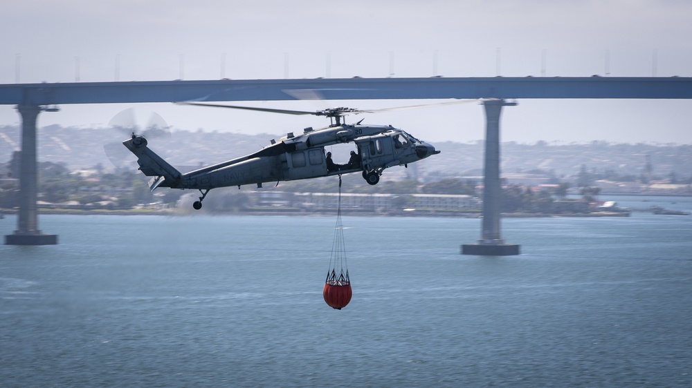 Sailors and federal San Diego firefighters fight fire aboard USS Bonhomme Richard