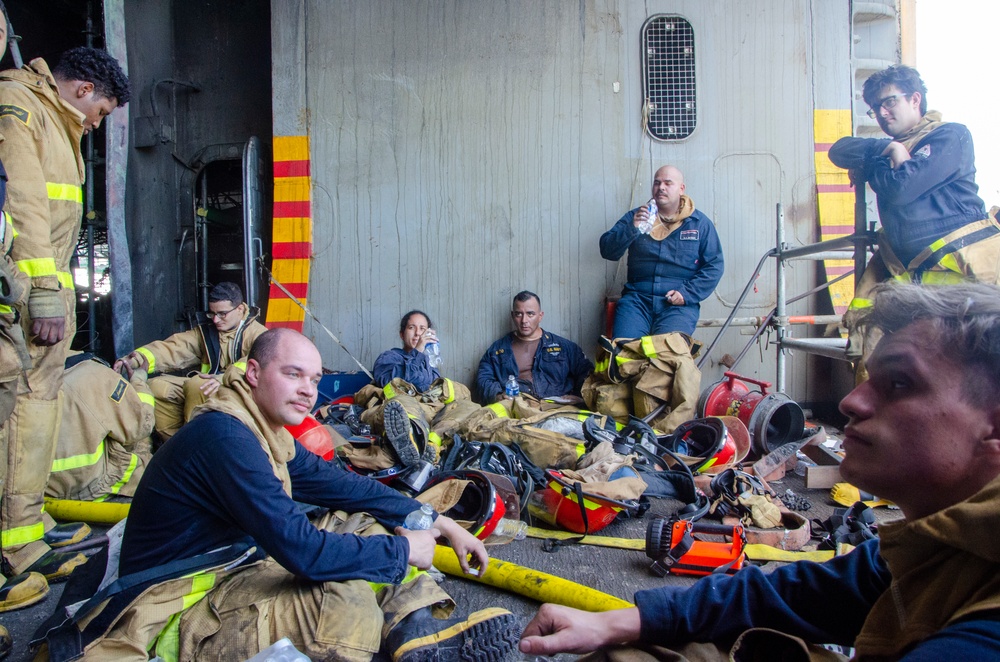 Sailors and federal San Diego firefighters fight fire aboard USS Bonhomme Richard