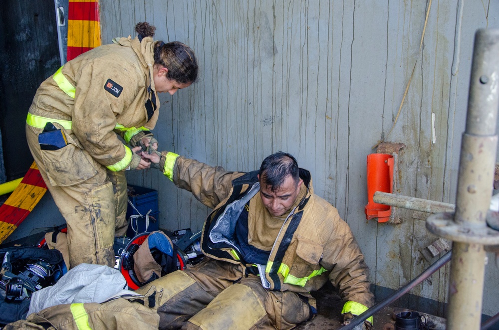 Sailors and federal San Diego firefighters fight fire aboard USS Bonhomme Richard