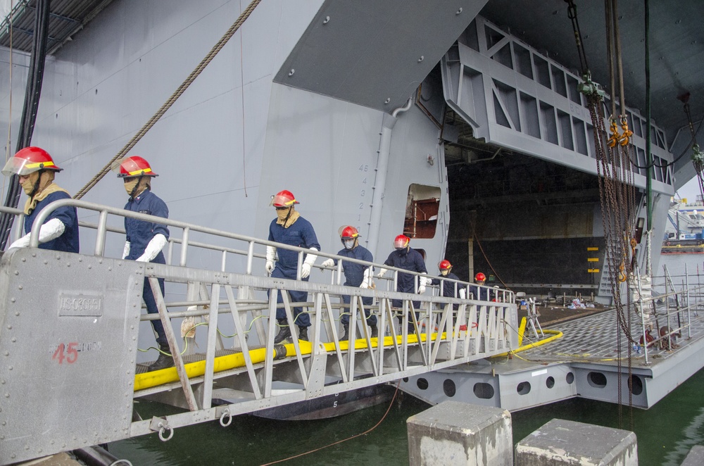 Sailors and federal San Diego firefighters fight fire aboard USS Bonhomme Richard