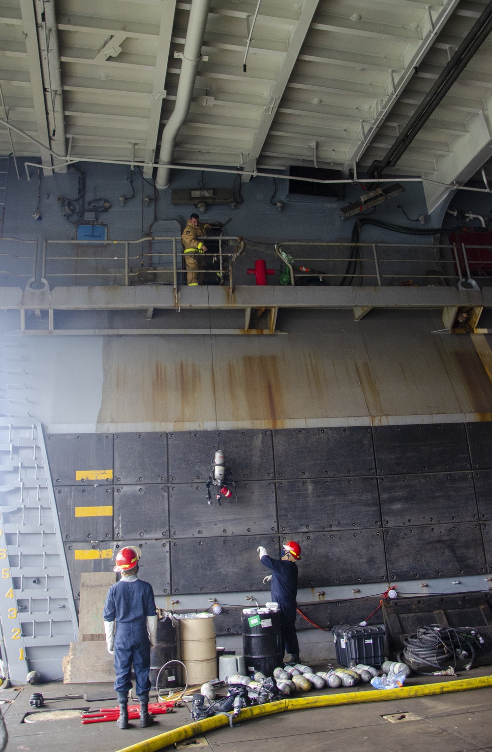 Sailors and federal San Diego firefighters fight fire aboard USS Bonhomme Richard