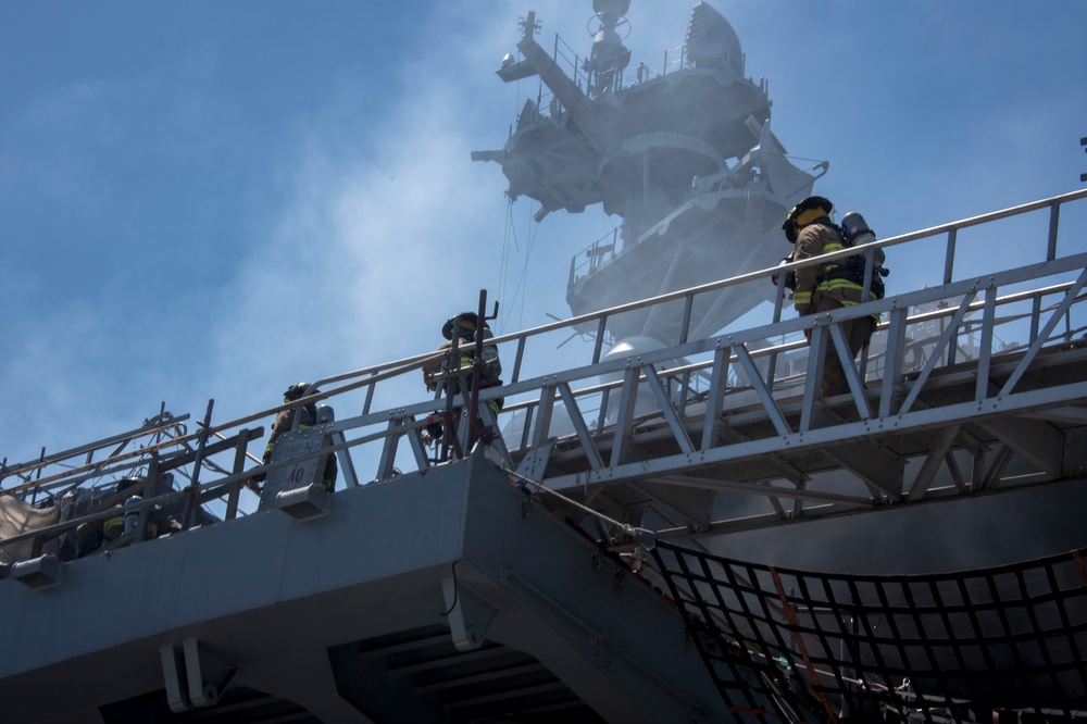 Sailors and federal San Diego firefighters fight fire aboard USS Bonhomme Richard