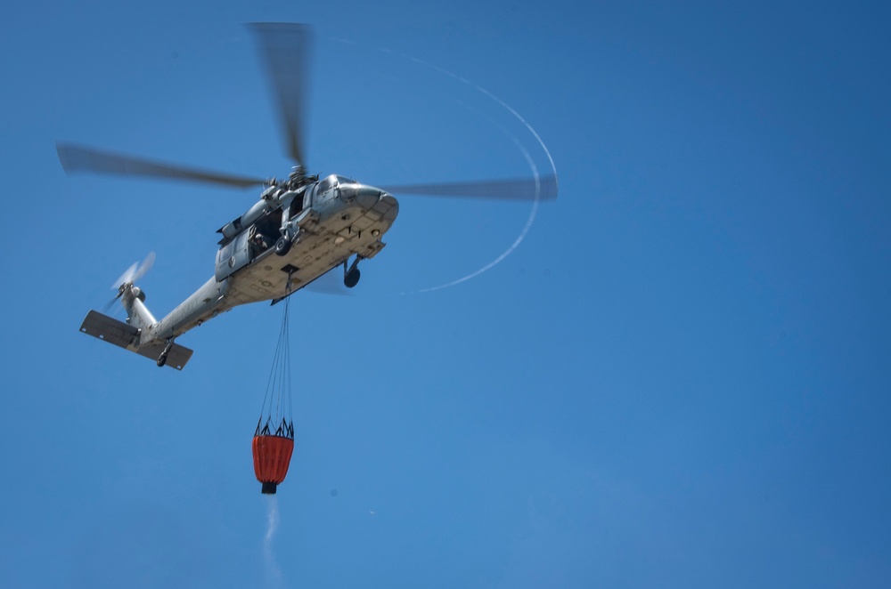 Sailors and federal San Diego firefighters fight fire aboard USS Bonhomme Richard