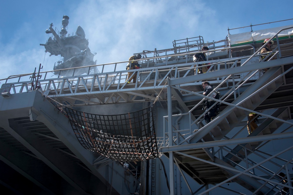 Sailors and federal San Diego firefighters fight fire aboard USS Bonhomme Richard