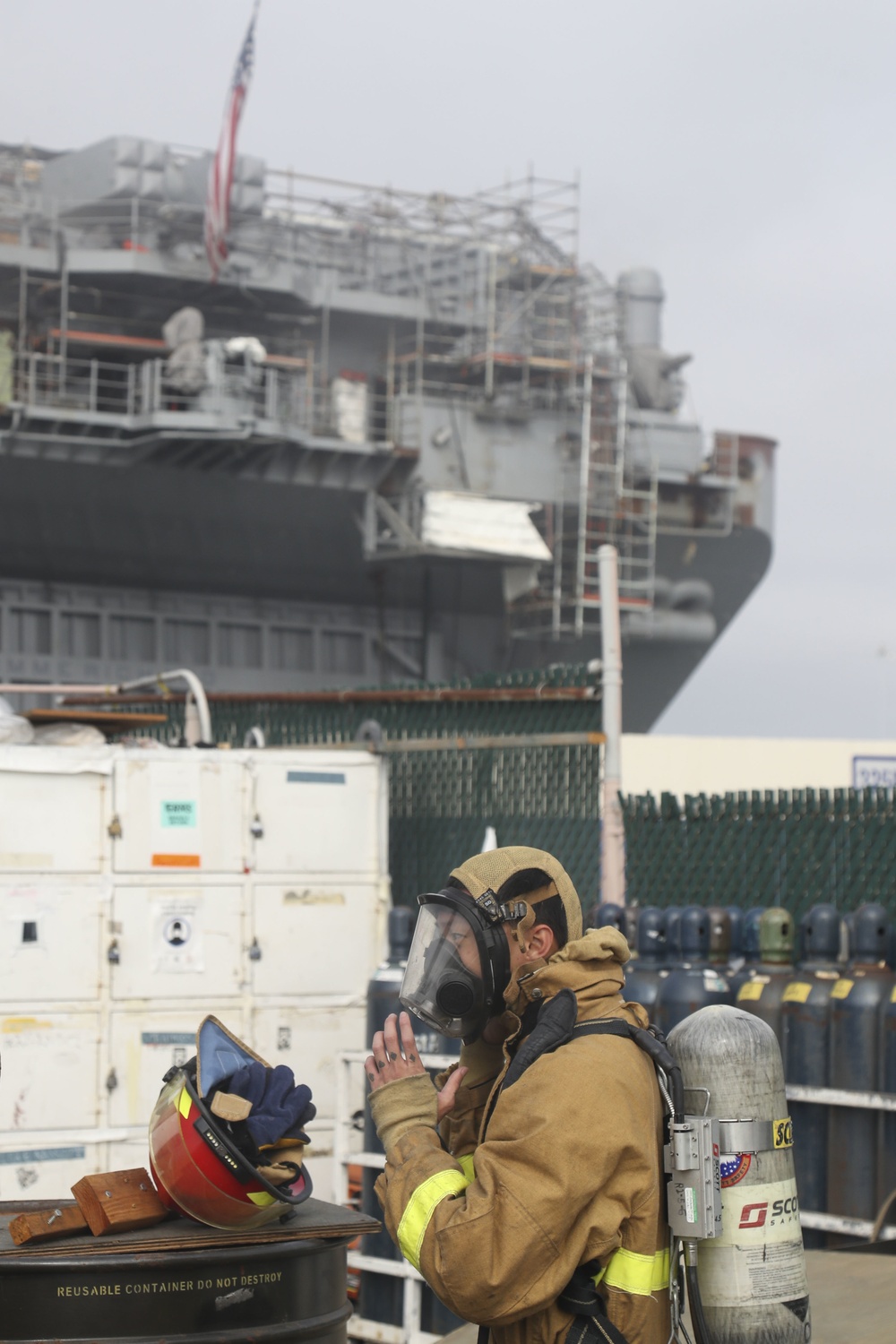 Sailors and federal San Diego firefighters fight fire aboard USS Bonhomme Richard