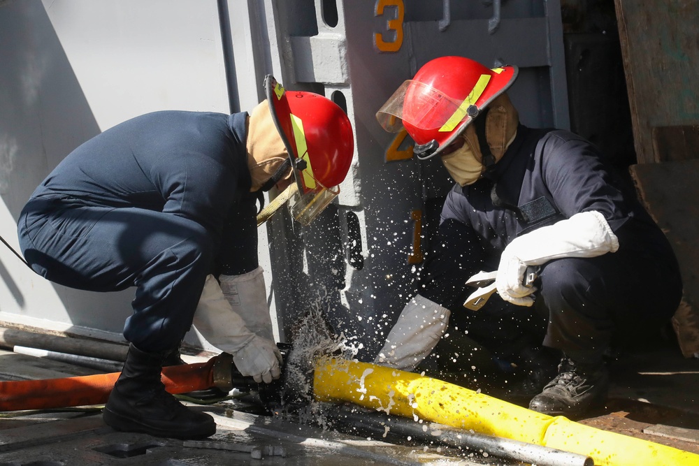 Sailors and federal San Diego firefighters fight fire aboard USS Bonhomme Richard