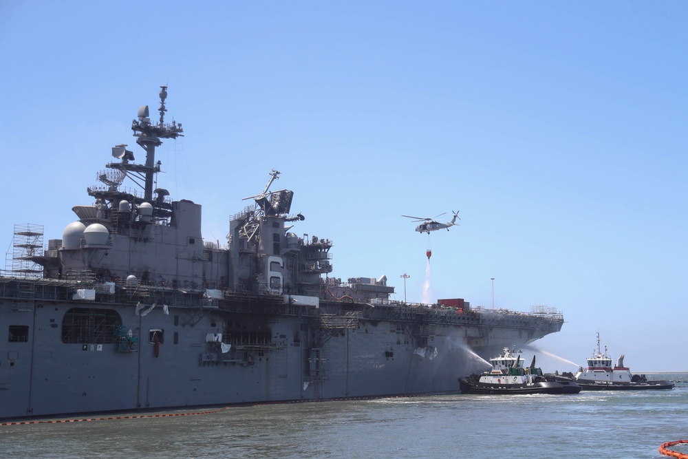 Sailors and federal San Diego firefighters fight fire aboard USS Bonhomme Richard