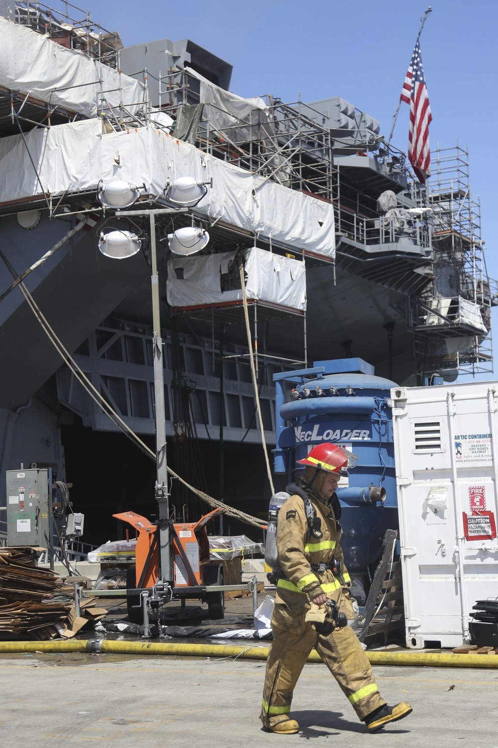 Sailors and federal San Diego firefighters fight fire aboard USS Bonhomme Richard