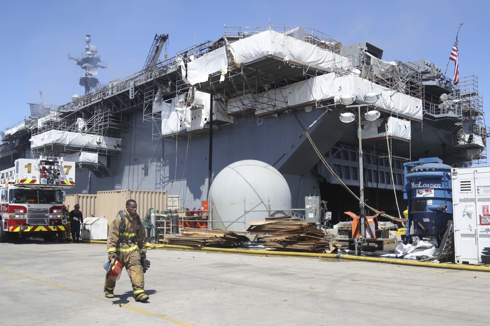 Sailors and federal San Diego firefighters fight fire aboard USS Bonhomme Richard