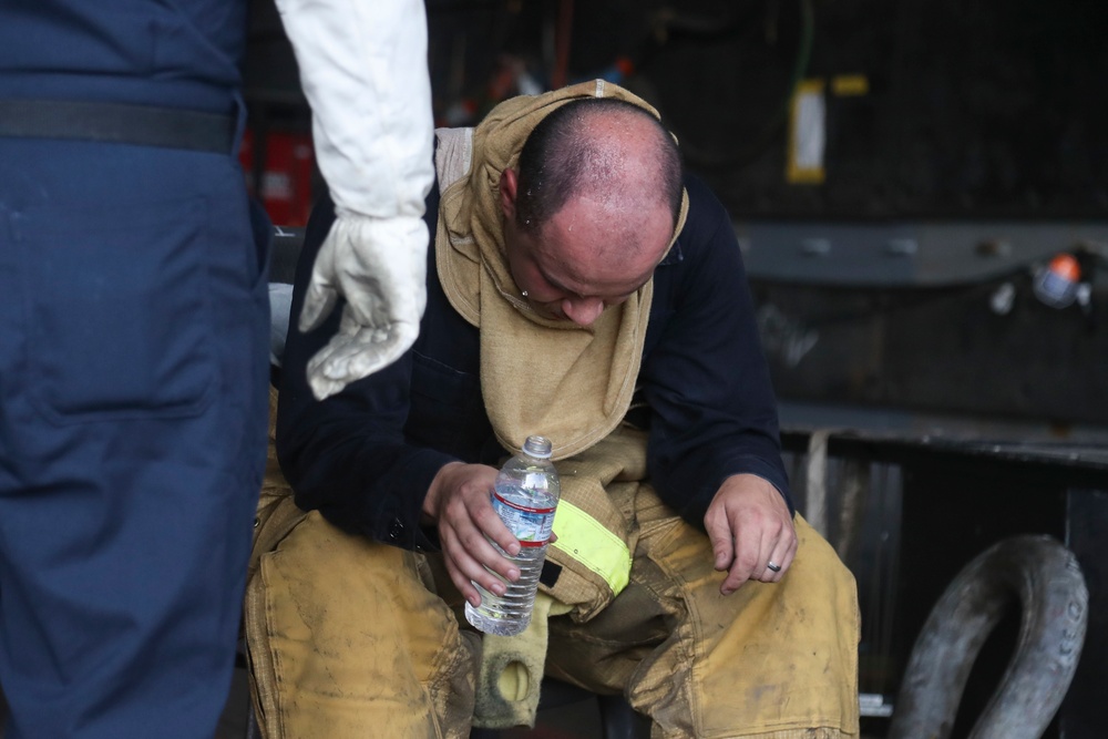 Sailors and federal San Diego firefighters fight fire aboard USS Bonhomme Richard