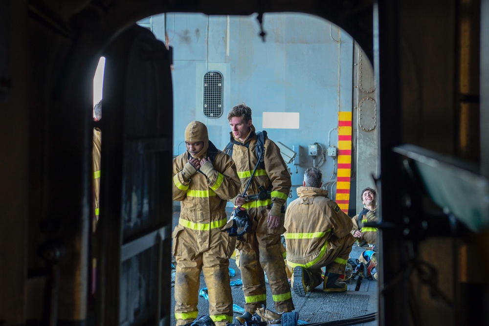 Sailors and federal San Diego firefighters fight fire aboard USS Bonhomme Richard