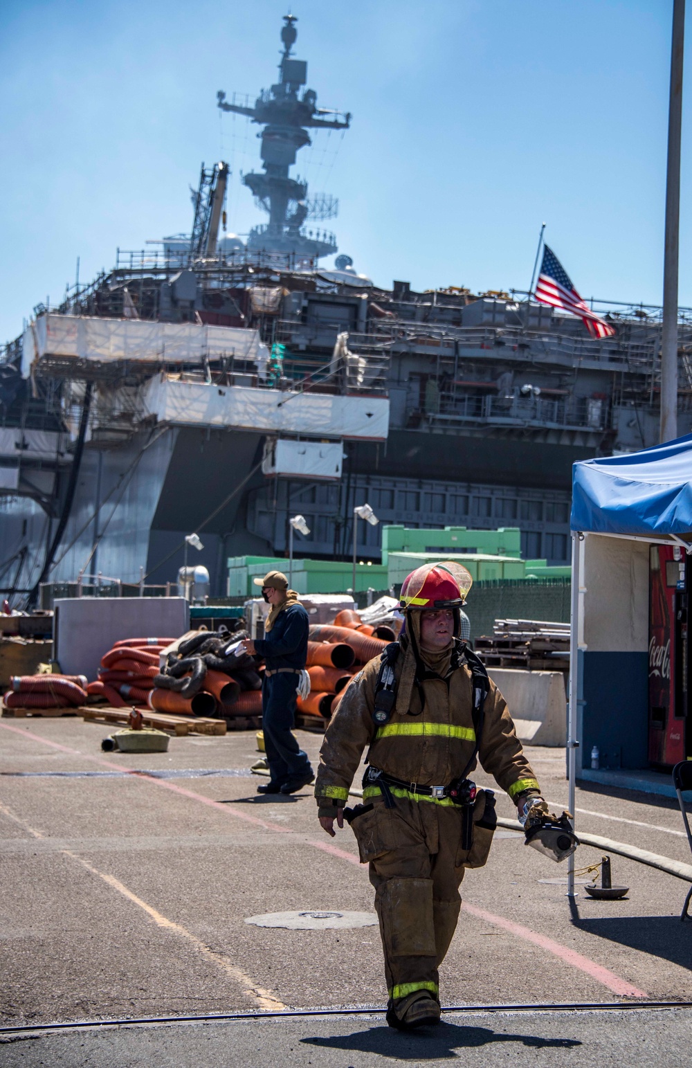 Sailors and federal San Diego firefighters fight fire aboard USS Bonhomme Richard