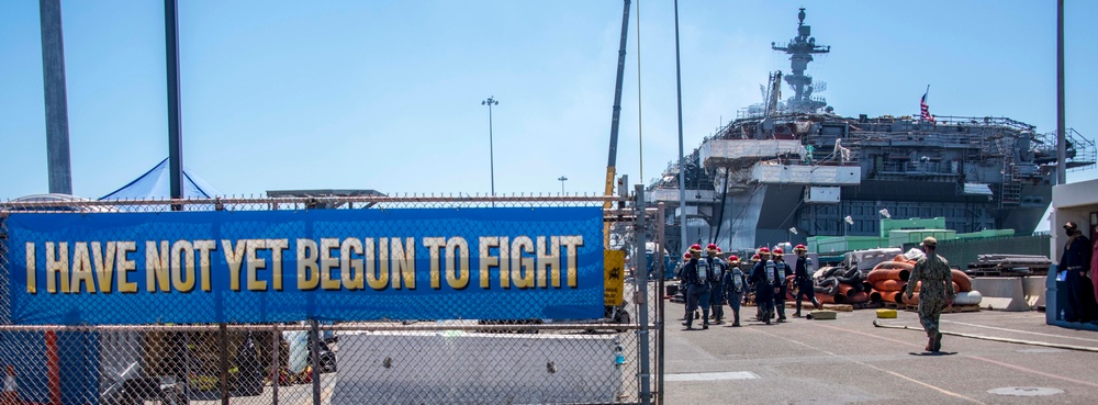 Sailors and federal San Diego firefighters fight fire aboard USS Bonhomme Richard