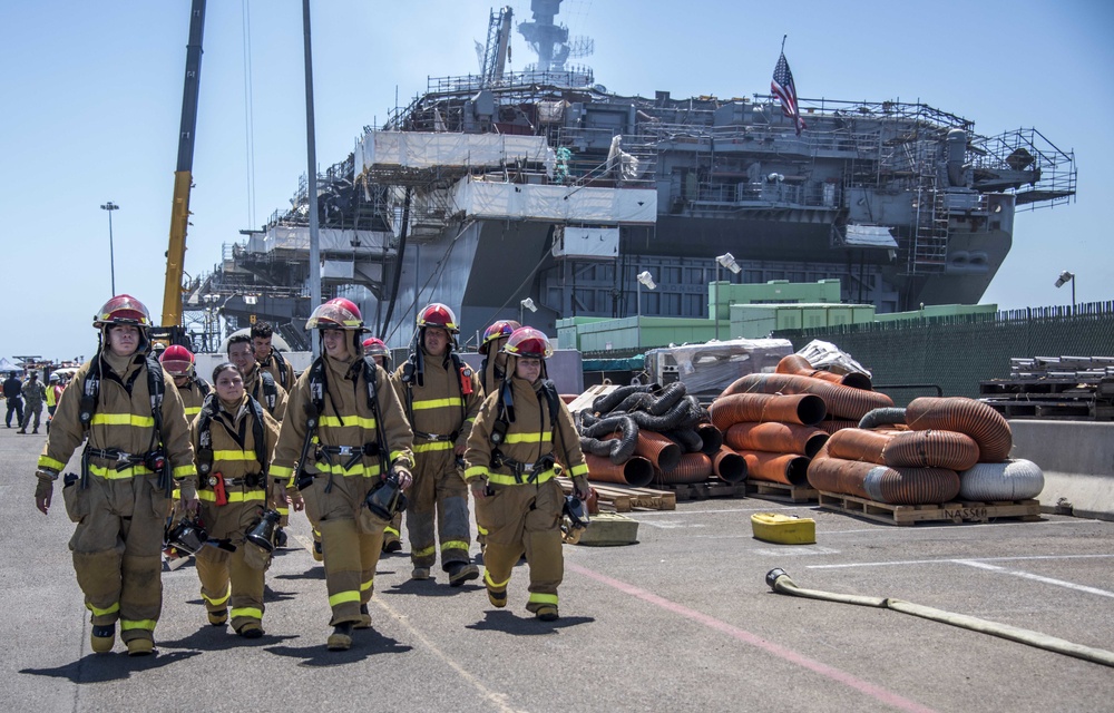 Sailors and federal San Diego firefighters fight fire aboard USS Bonhomme Richard