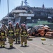 Sailors and federal San Diego firefighters fight fire aboard USS Bonhomme Richard