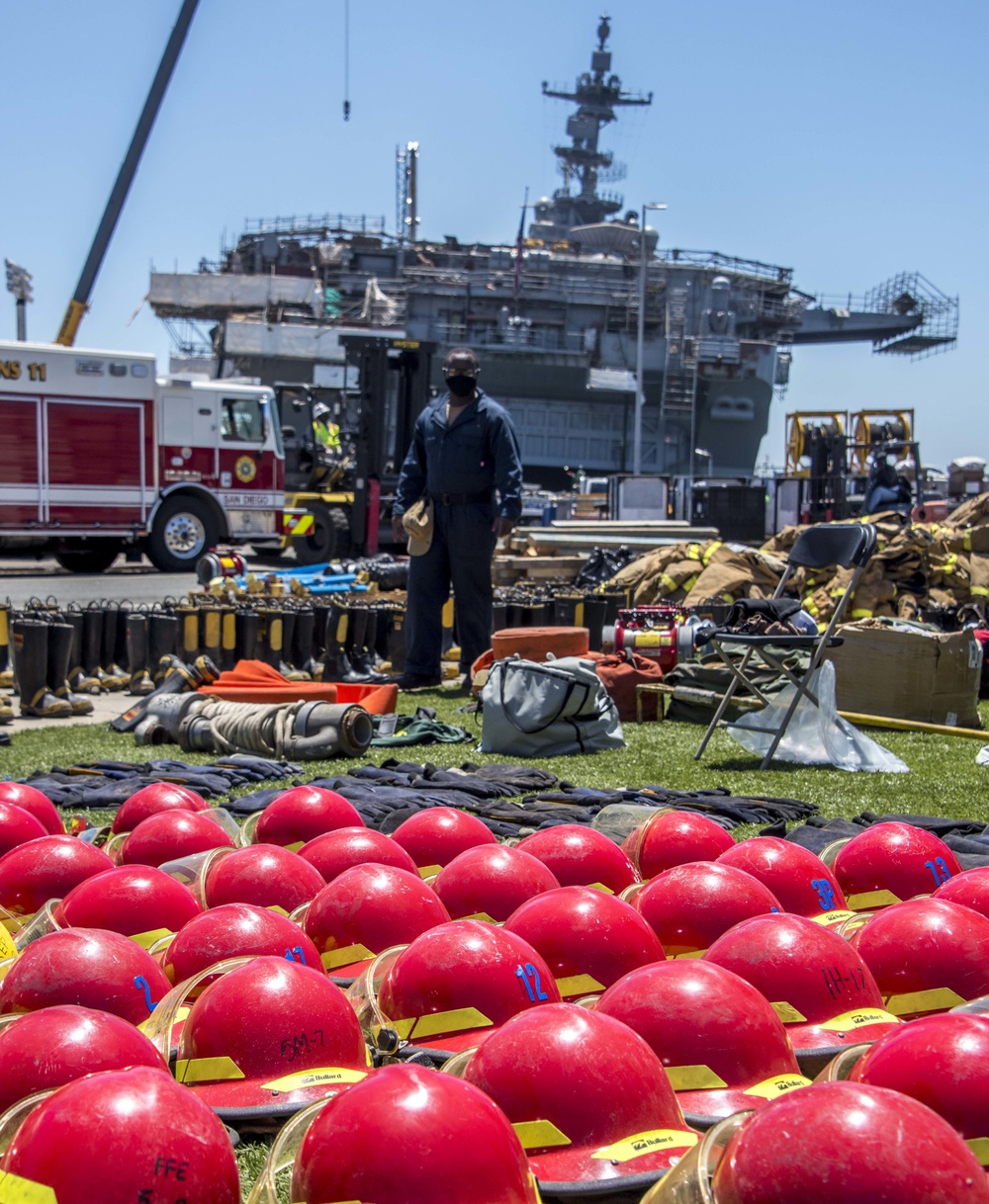 Sailors and federal San Diego firefighters fight fire aboard USS Bonhomme Richard