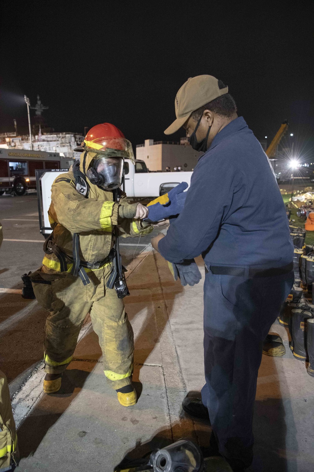 Sailors and federal San Diego firefighters fight fire aboard USS Bonhomme Richard