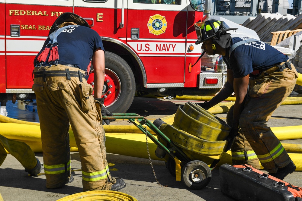 Sailors and federal San Diego firefighters fight fire aboard USS Bonhomme Richard