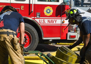 Sailors and federal San Diego firefighters fight fire aboard USS Bonhomme Richard