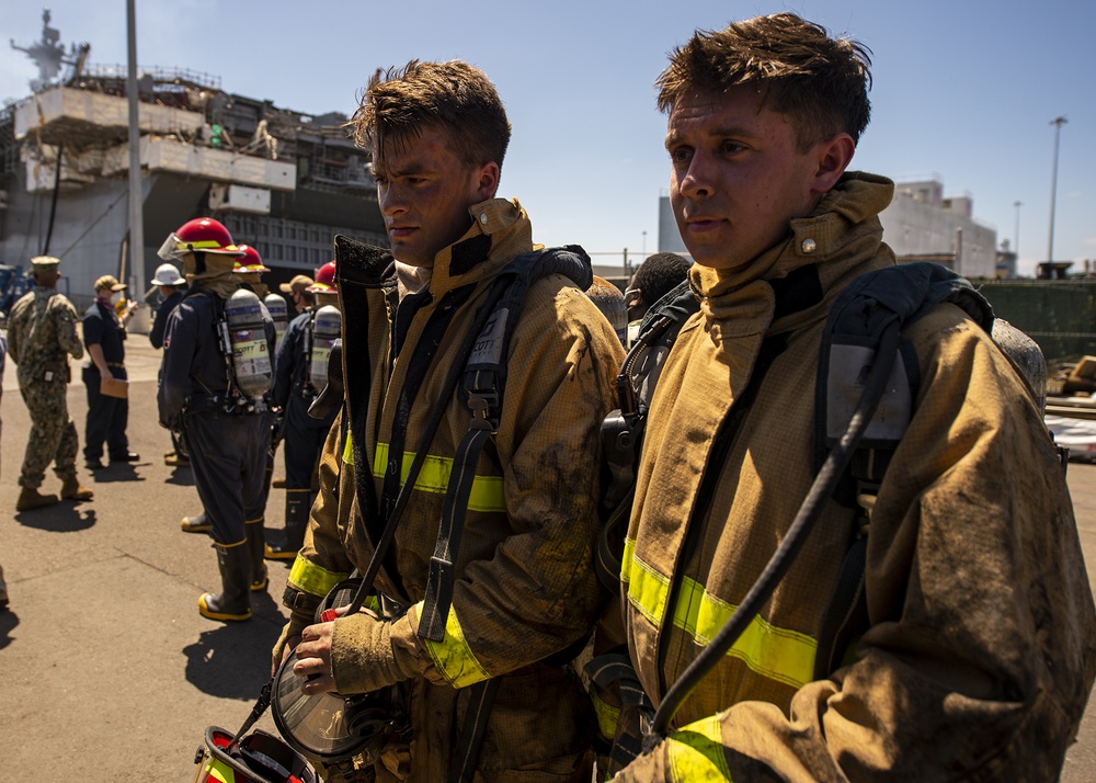 Sailors and federal San Diego firefighters fight fire aboard USS Bonhomme Richard