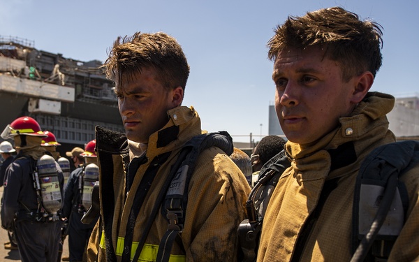 Sailors and federal San Diego firefighters fight fire aboard USS Bonhomme Richard