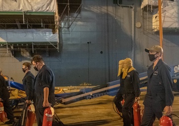 Sailors and federal San Diego firefighters fight fire aboard USS Bonhomme Richard