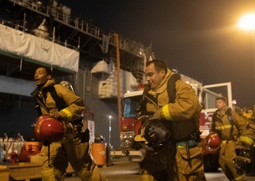 Sailors and federal San Diego firefighters fight fire aboard USS Bonhomme Richard