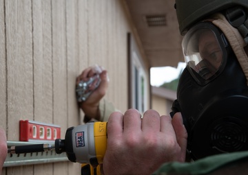 Structures specialist prepares to mount an air conditioning unit to a building