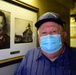 Grandson of historic Coast Guard figure poses next to grandfather's portrait