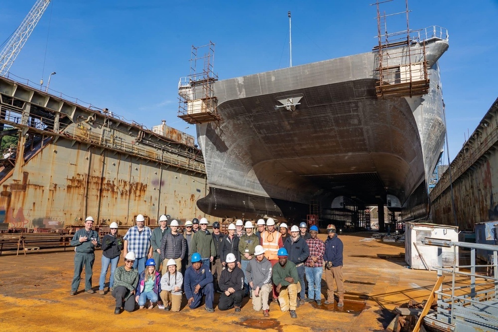 Team members from USNS Trenton's regular overhaul pose in front of ship