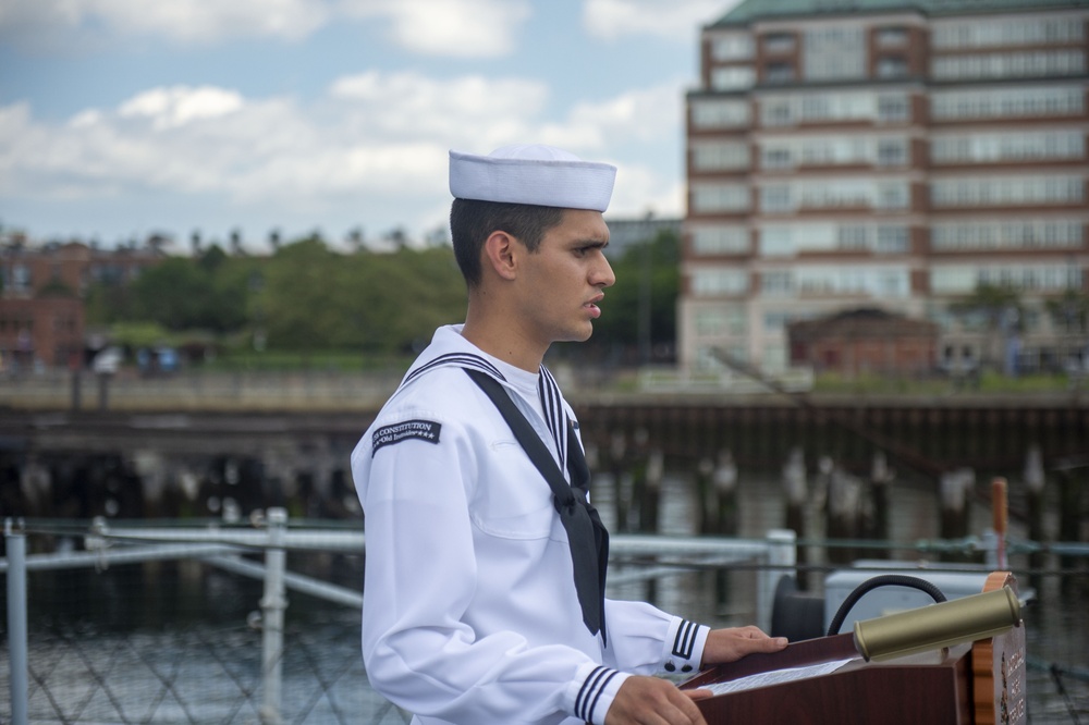 Culinary Specialist 3rd Class Abdon Vivastejada reads the names of sailors that lost their lives during the kamikaze attack aboard the USS Cassin Young