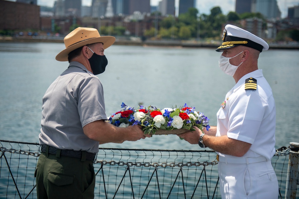 Michael Creasey, Superintendent for the National Parks of Boston and USS Constitution Commanding Officer Cmdr. John Benda perform a reef ceremony for the 75th anniversary of the kamikaze attacks on USS Cassin Young (DD 793)