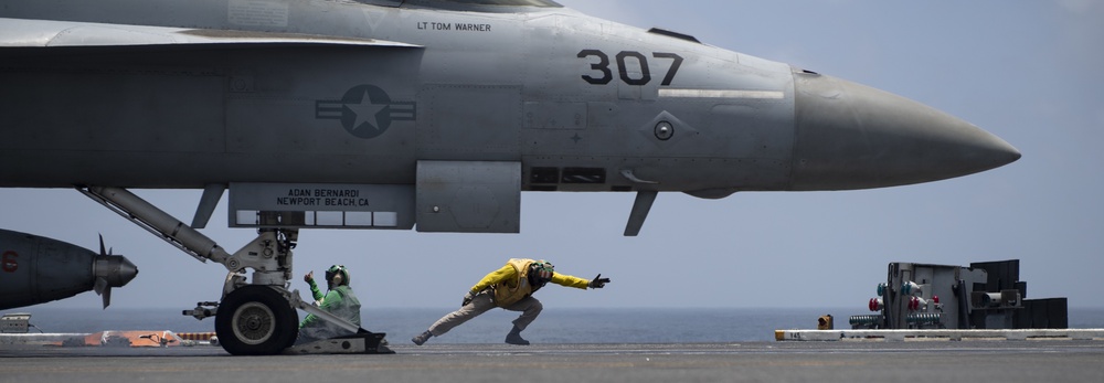 A Sailor signals to launch an aircraft.