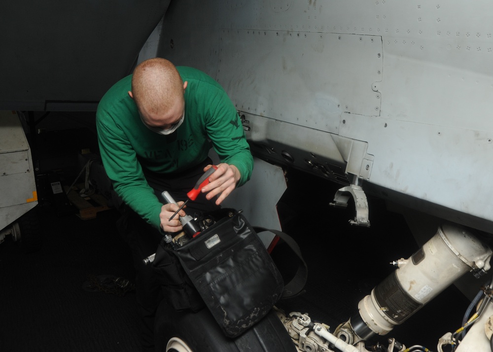 U.S. Navy Sailor Inspects Landing Gear