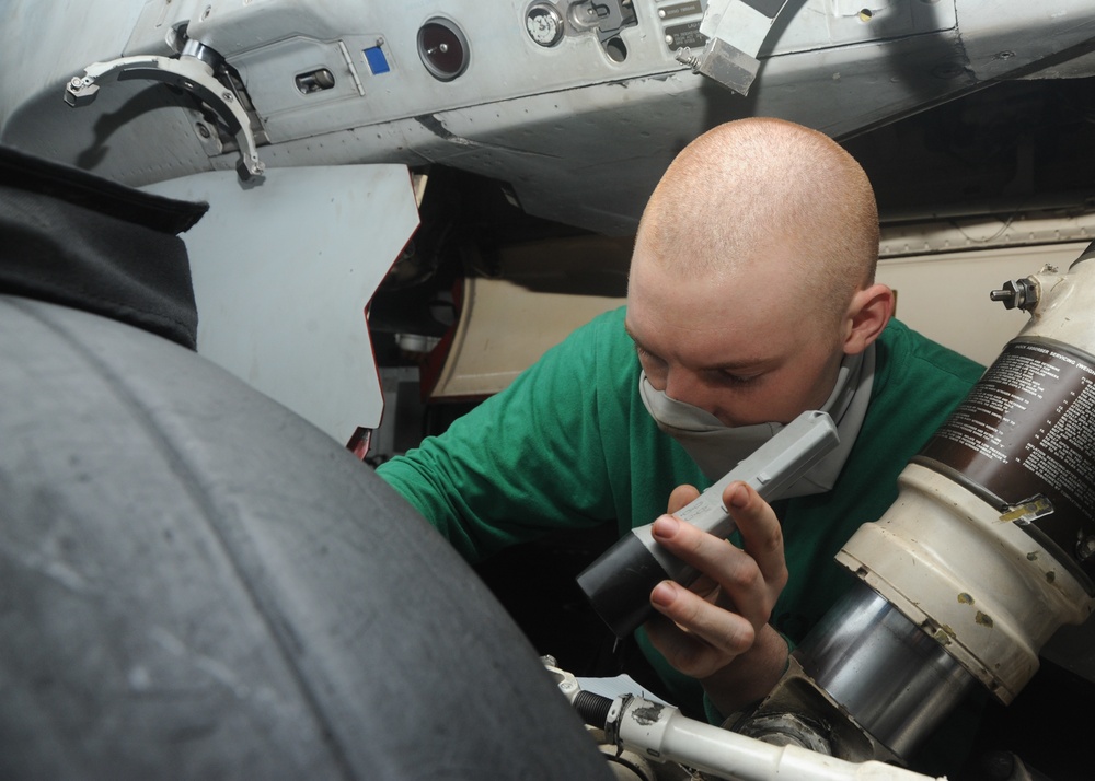 U.S. Navy Sailor Inspects Landing Gear